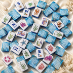 Luxury ocean-themed mahjong tiles scattered on ivory satin with seashells, coral, and shimmering blue backs.
