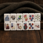 Knitting-themed mahjong tiles arranged in two rows on dark wood with a cozy brown fabric background
