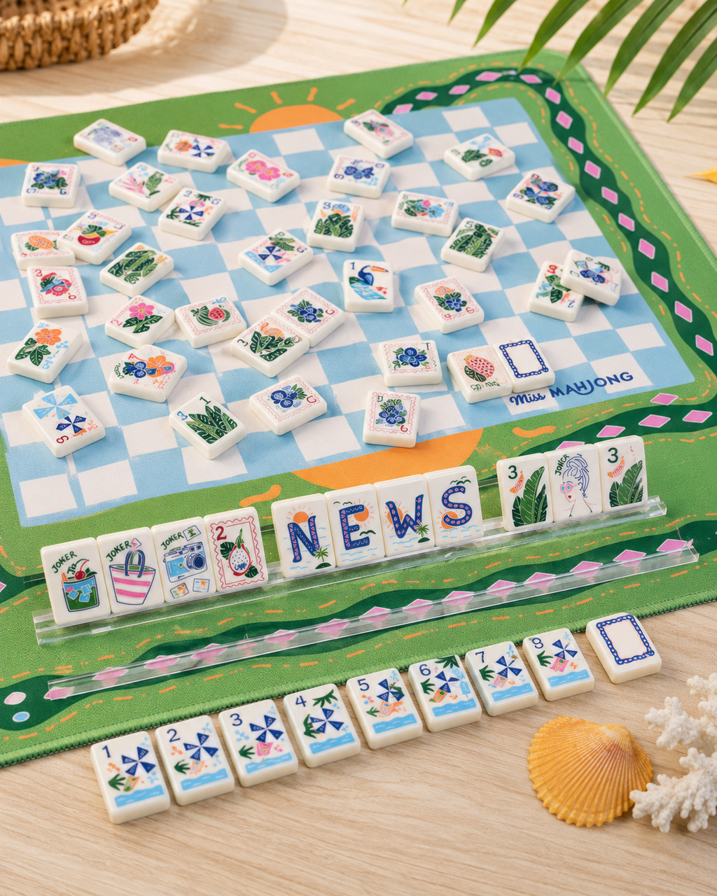 Close-up of colorful American Mahjong tiles with tropical leaves, joker artwork, flowers, and beach-inspired illustrations