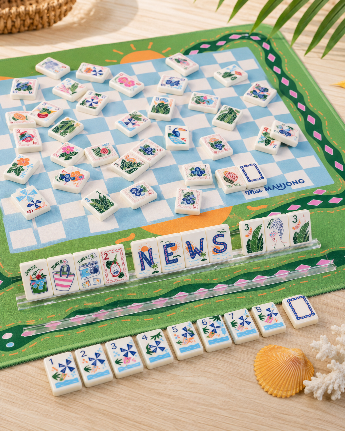 Close-up of colorful American Mahjong tiles with tropical leaves, joker artwork, flowers, and beach-inspired illustrations