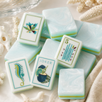 Close-up of glossy aqua and white mahjong tiles with tropical Joker artwork