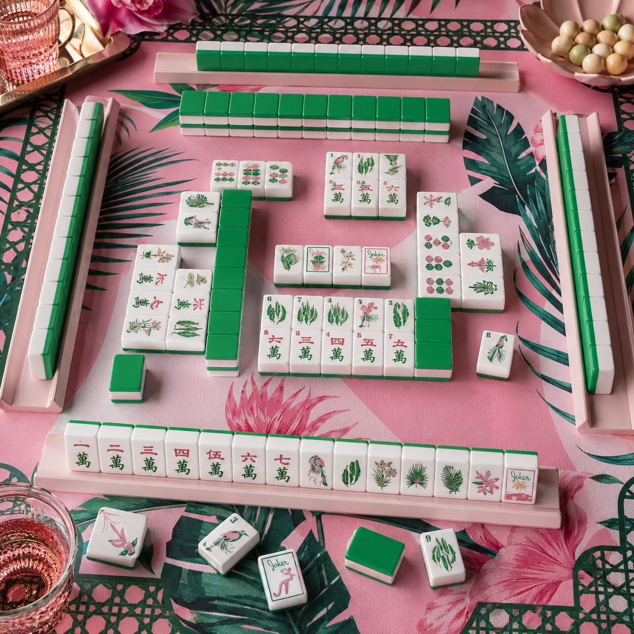 Close-up of tropical mahjong tiles with green backs and pink layered sides