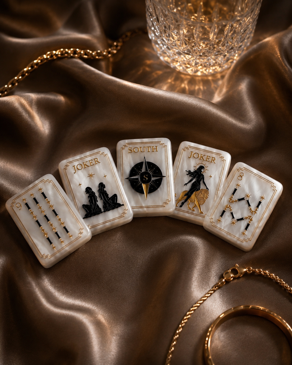 Pearl white American Mahjong tiles arranged on bronze satin with crystal glass and gold accents