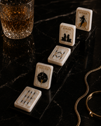 Pearl American Mahjong tiles in a cascading arrangement on polished black marble