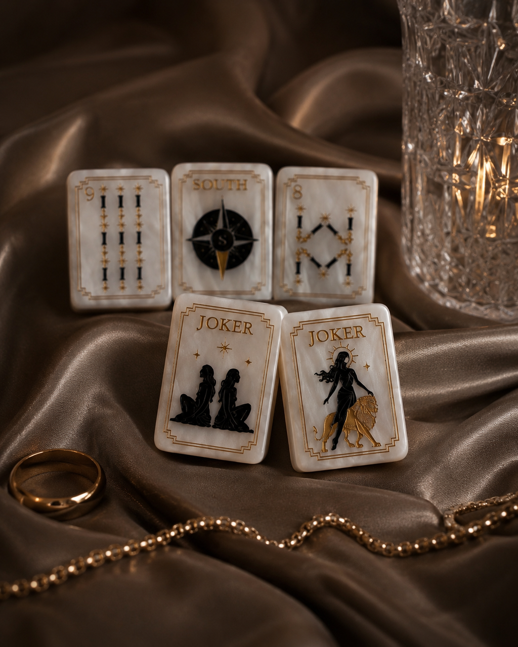 Black and gold Celestial Pearl Mahjong tiles layered on champagne brown satin