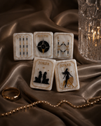 Black and gold Celestial Pearl Mahjong tiles layered on champagne brown satin