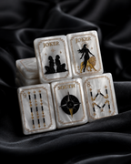 Pearl white Mahjong tiles stacked on black silk with gold and black celestial artwork