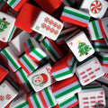 A Christmas-themed mahjong tile set for holiday game nights, festive gifting, and seasonal display. The red, green, and white layered tiles include Christmas trees, candy canes, Santa-style jokers, and other holiday details.