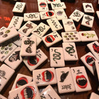 A gothic-inspired mahjong tile set made for Halloween game nights, dark fantasy collectors, and players who want a bold alternative to traditional mahjong tiles. The design includes snakes, skulls, vampire teeth, spiders, bats, roses, and gothic-style jokers on a soft pink tile base.