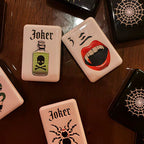 A gothic-inspired mahjong tile set made for Halloween game nights, dark fantasy collectors, and players who want a bold alternative to traditional mahjong tiles. The design includes snakes, skulls, vampire teeth, spiders, bats, roses, and gothic-style jokers on a soft pink tile base.