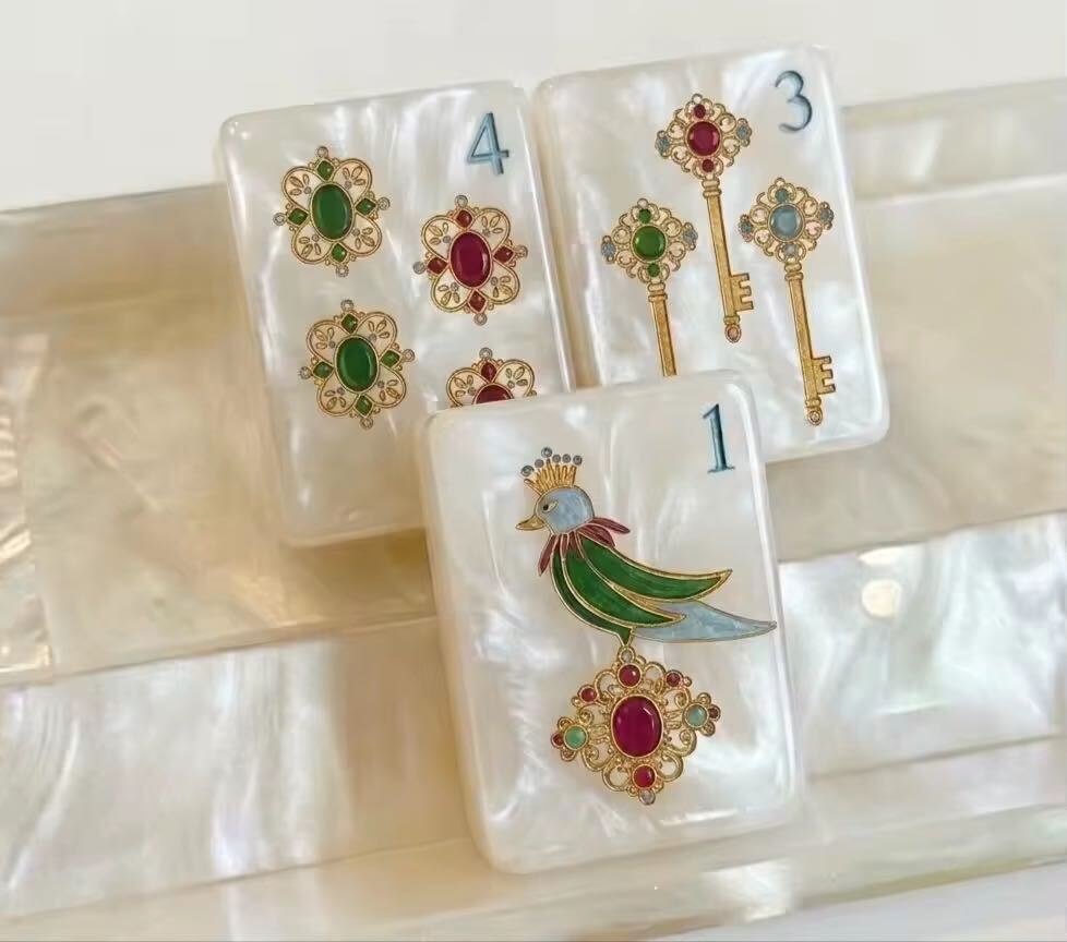 Decorative playing cards with gemstone and key designs on a white surface