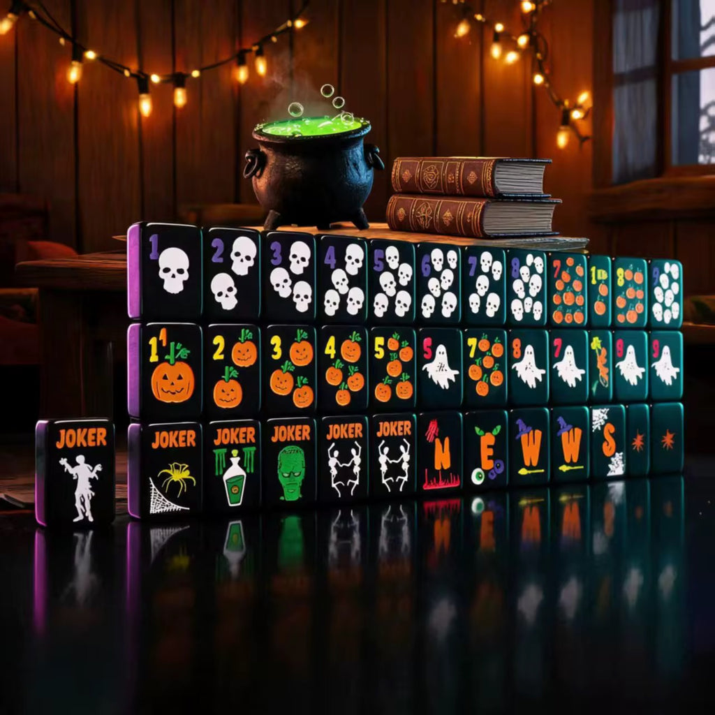Halloween mahjong set displayed upright with black tiles featuring skulls, ghosts, pumpkins and colorful spooky symbols.