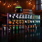 Halloween mahjong set displayed upright with black tiles featuring skulls, ghosts, pumpkins and colorful spooky symbols.