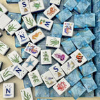 Ocean-themed mahjong tiles scattered across a light surface, featuring colorful sea-life illustrations and blue marbled backs.
